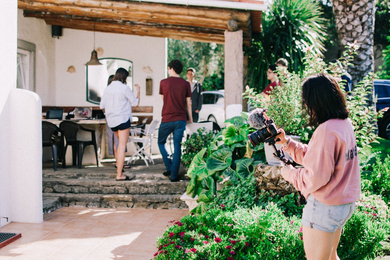 person with camera outside of house
